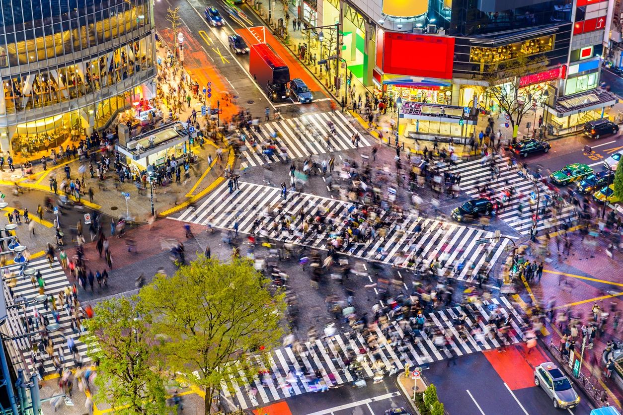 Busy nighttime pedestrian scramble crossing in Tokyo