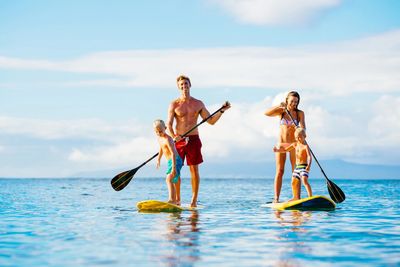 a family paddle boarding in the ocean