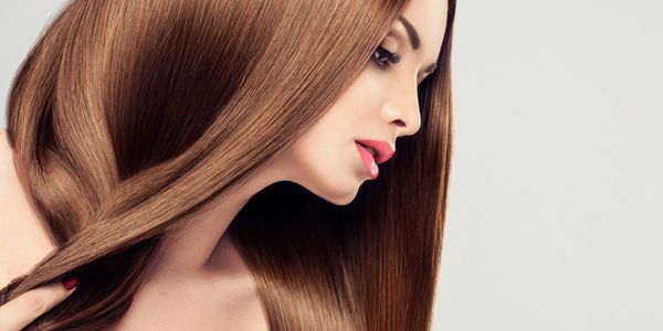 Close-up of a woman with long, smooth, shiny brown hair.