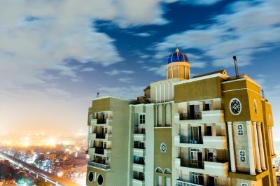 Tall building with blue dome at night.