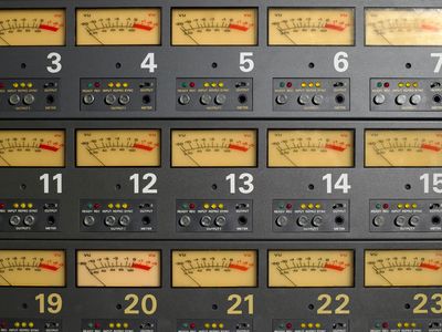 Close-up of numbered audio VU meters on a control panel.