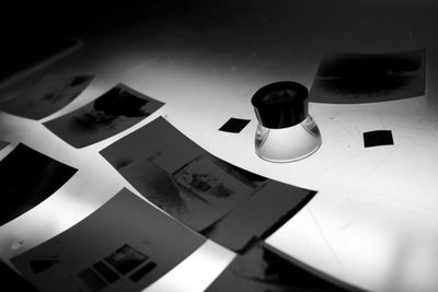 Black and white photo negatives spread out with a magnifying loupe under focused light.