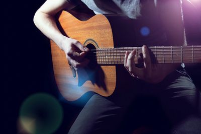 person playing an acoustic guitar lessons and repairs