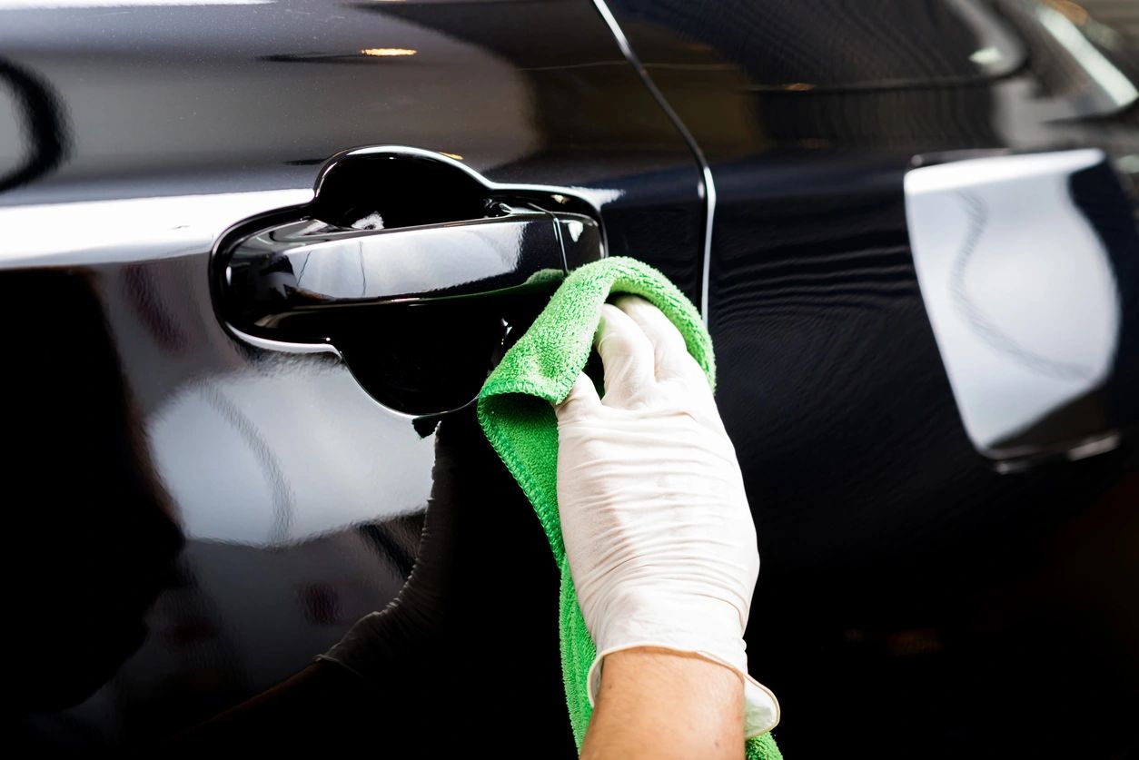 Professional staff member carefully polishing a car door 
