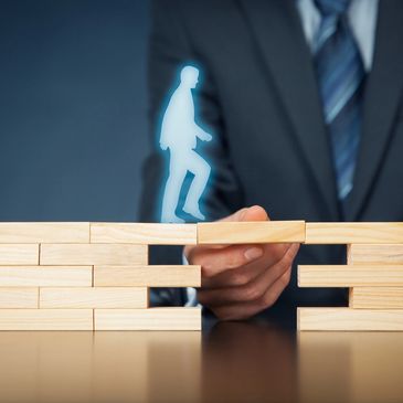 Businessman climbing  the corporate ladder of wooden blocks