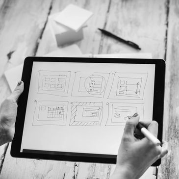 Person sketching layouts on a digital tablet.