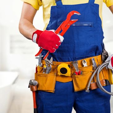 Worker holding a wrench with a tool belt.