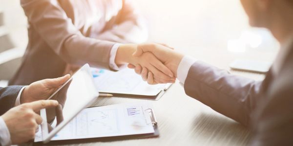 Two businessman shaking hands on a deal.