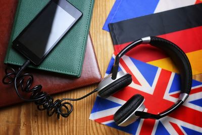 Smartphone and headphones on a desk with some flags