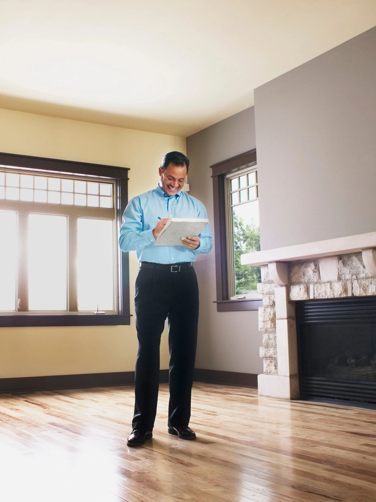 Man in blue shirt inspecting a house.