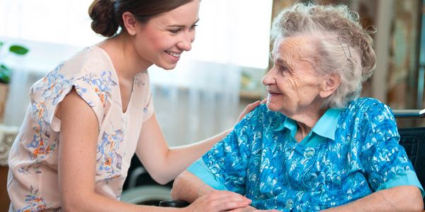 Caregiver smiling at senior client.