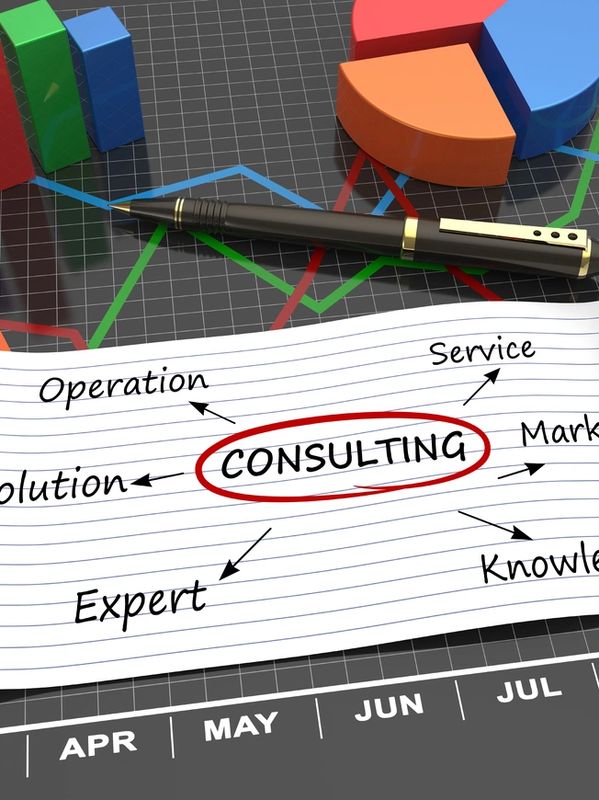 Pen on paper with 'CONSULTING' circled, surrounded by related business terms and charts.