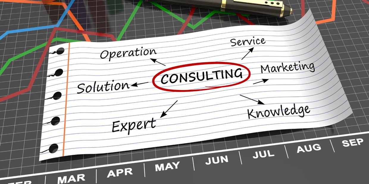 A note with consulting-related terms on a financial graph background with charts and a pen.