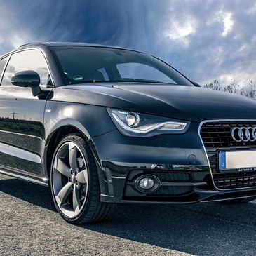 detailed photo of a cleaned Audi on a road with dark clouds in the background