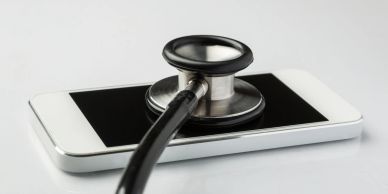 A stethoscope placed on a smartphone, symbolizing mobile health.