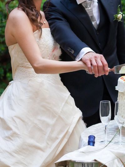 Bride and groom cutting their wedding cake together at reception.