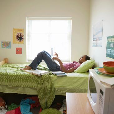 a woman with a laptop lying on the bed 