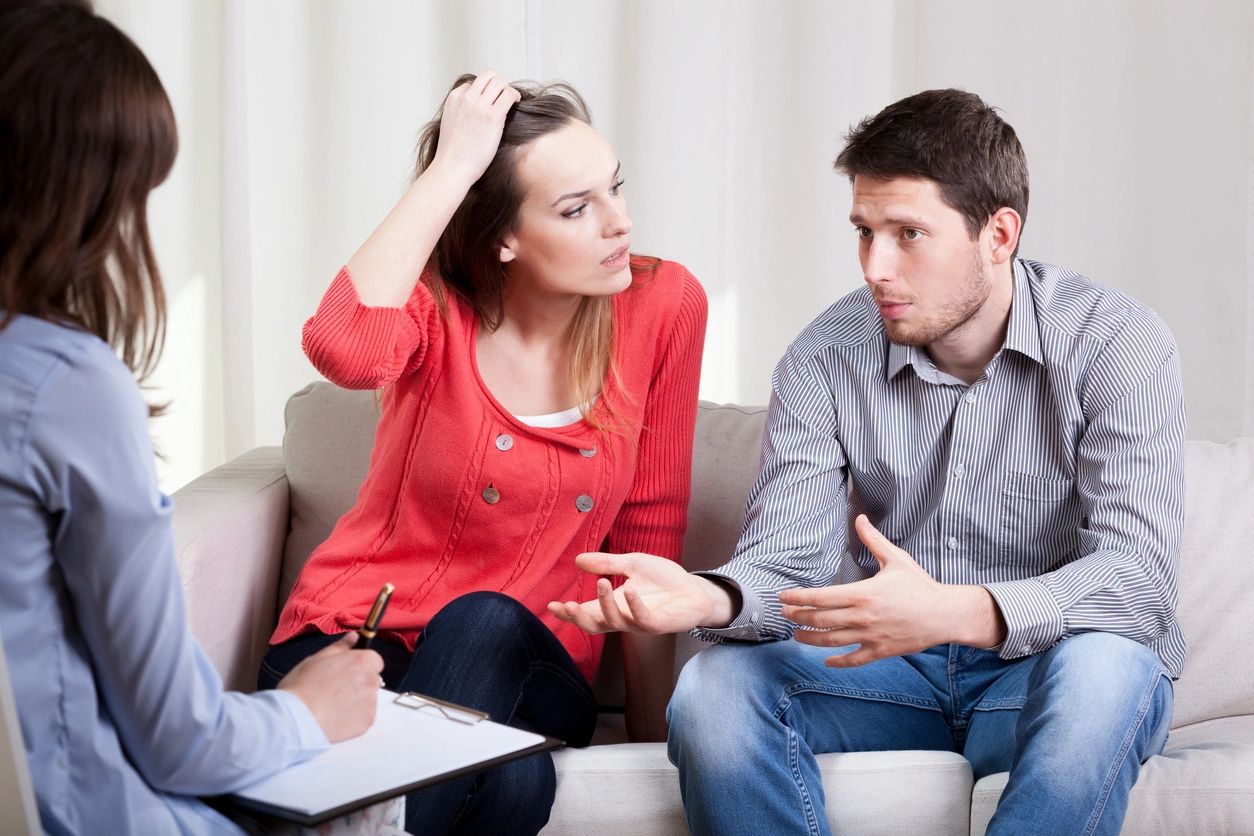 Couple discussing issues with a therapist in a counseling session.