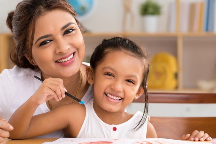 young child happy coloring with mother