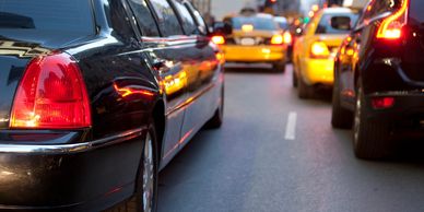 Black limousine driving through traffic in the city