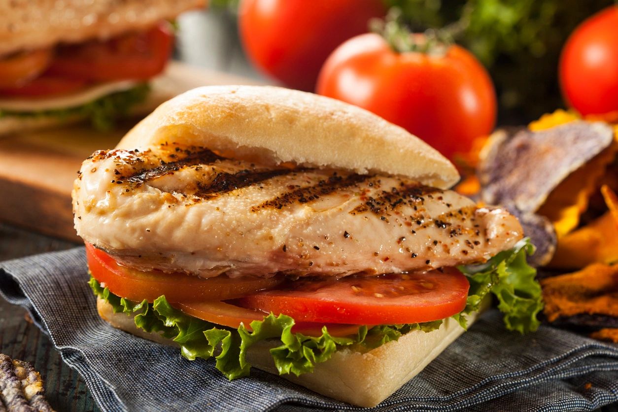 Close-up of a grilled chicken sandwich on ciabatta with fresh tomato and lettuce—perfect for clean eating, lean protein meals, or healthy lunch ideas.