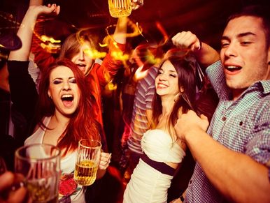 Group of friends enjoying drinks and dancing at a lively party.