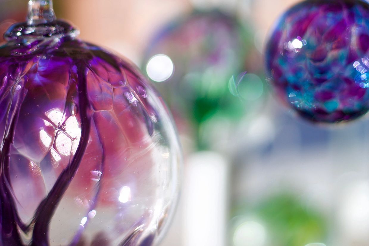 Close-up of colorful glass orbs with intricate designs and reflections.