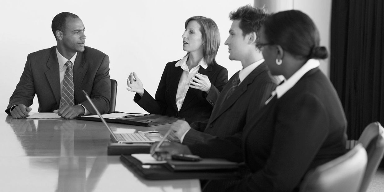 Senior management team meeting at a conference table.