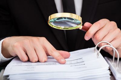 Person reading page with a magnifying glass