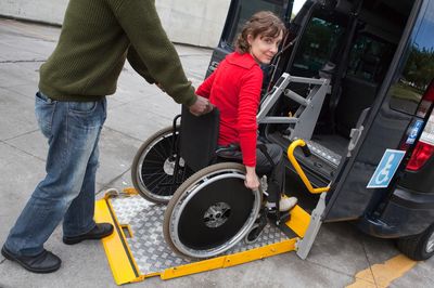 Woman in wheelchair using a van lift.