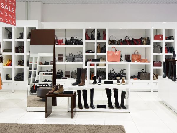 Display of boots and handbags in a stylish retail store.
