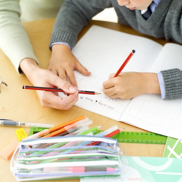 Child learning handwriting from an adult