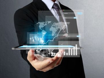 Businessman holding a tablet with futuristic digital data projections.