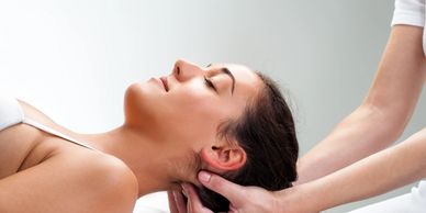 A woman relaxing while receiving a neck massage.