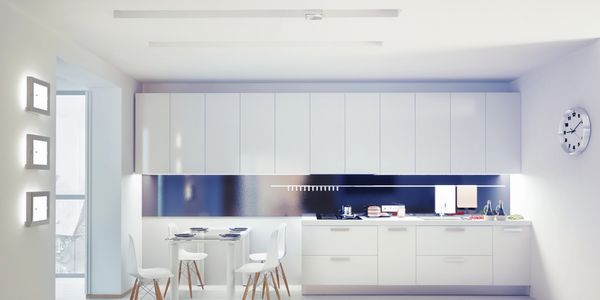 Sleek modern kitchen with white cabinets and minimalist dining area.