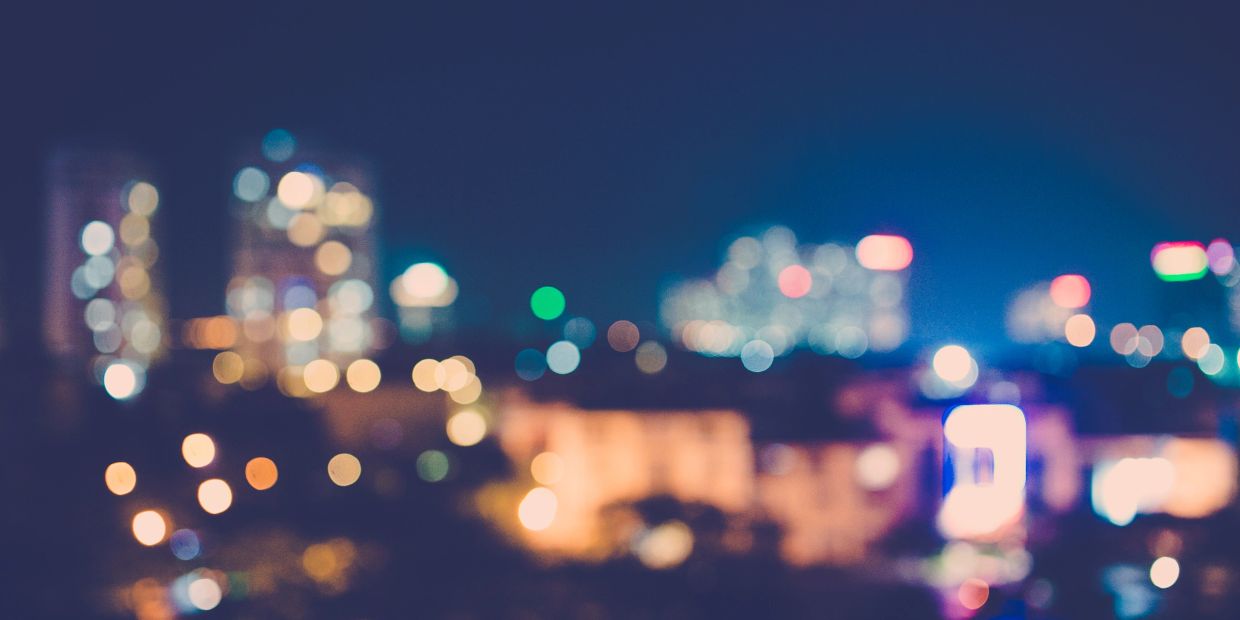 Blurred cityscape with colorful bokeh lights at night.
