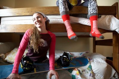 People in sober living and recovery housing bedroom sitting on bunk beds smiling