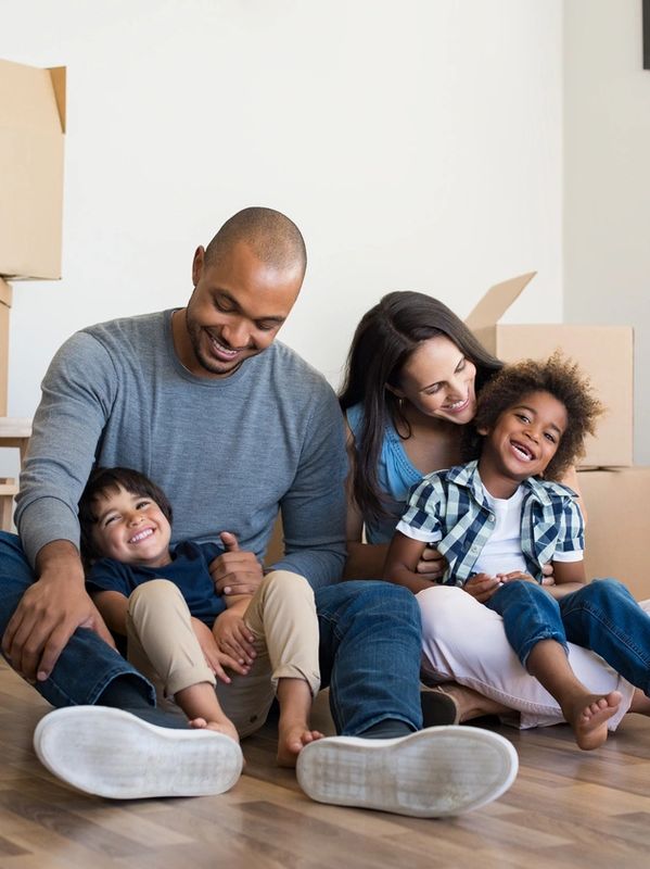 A family sitting on the floor in their new home