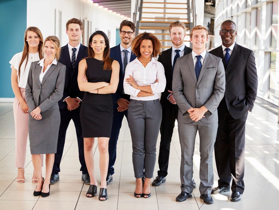 Diverse professional team posing confidently in a modern office space.