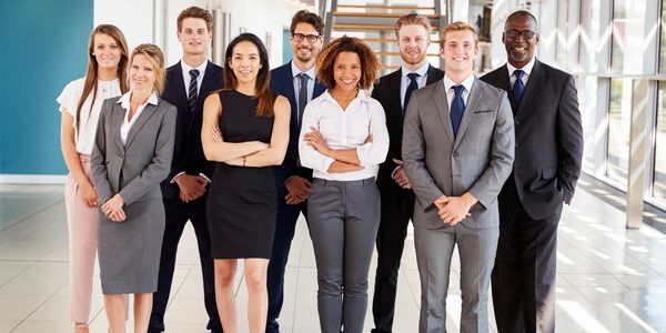 A team standing smiling at the camera in an office environment