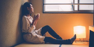 Woman relaxing with a cup by the window.