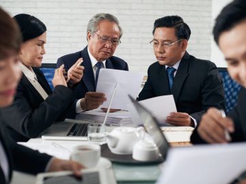 Business professionals reviewing documents in a meeting.