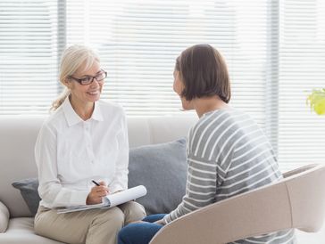 Two women having a counseling session in a bright room.