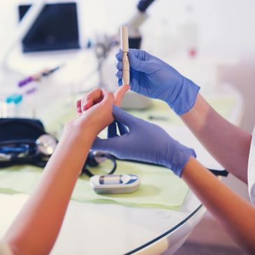 A healthcare professional tests a patient's blood sugar with a glucometer.