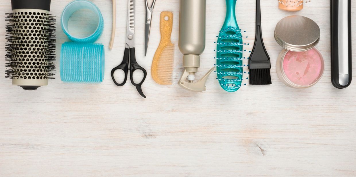 A row of hair styling tools and accessories neatly arranged on a wooden surface.