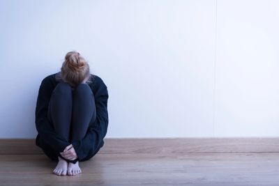 a person needing help with anxiety. 
a lone person sitting on a floor with anxiety