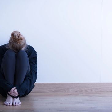 worried, troubled, upset person, sitting by the wall, hiding the face