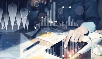 Person interacting with tablet displaying financial graphs and charts.