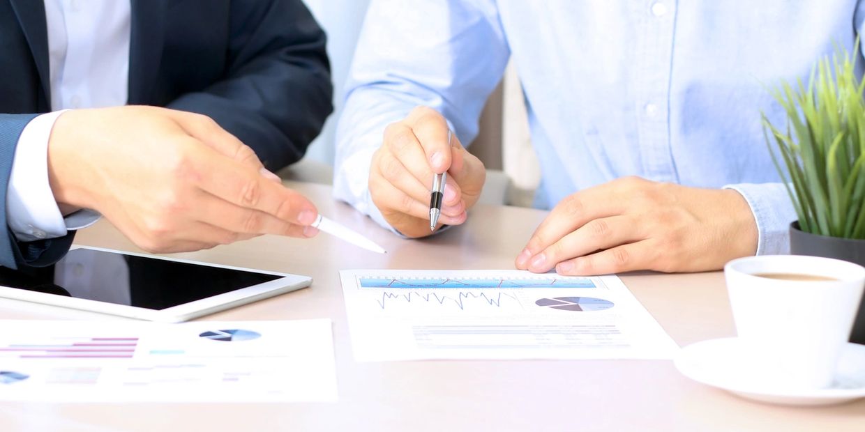 2 people's hands on a desk at a business meeting