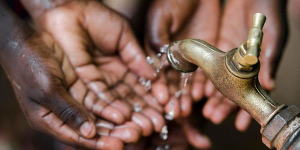 Hands enjoying new found running water and the Living Water of Christ